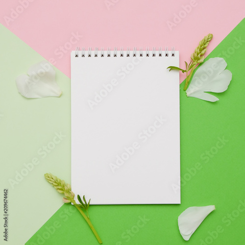 Composition with flowers and notebook on geometric background. Mock up for your design. Flat lay.