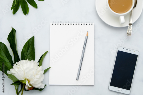 Composition with flowers  coffee  smartphone and notebook on white background. Mock up for your design. Flat lay.