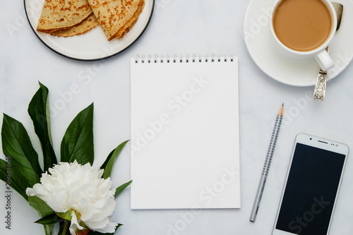 Composition with flowers, coffee, smartphone and notebook on white background. Mock up for your design. Flat lay.