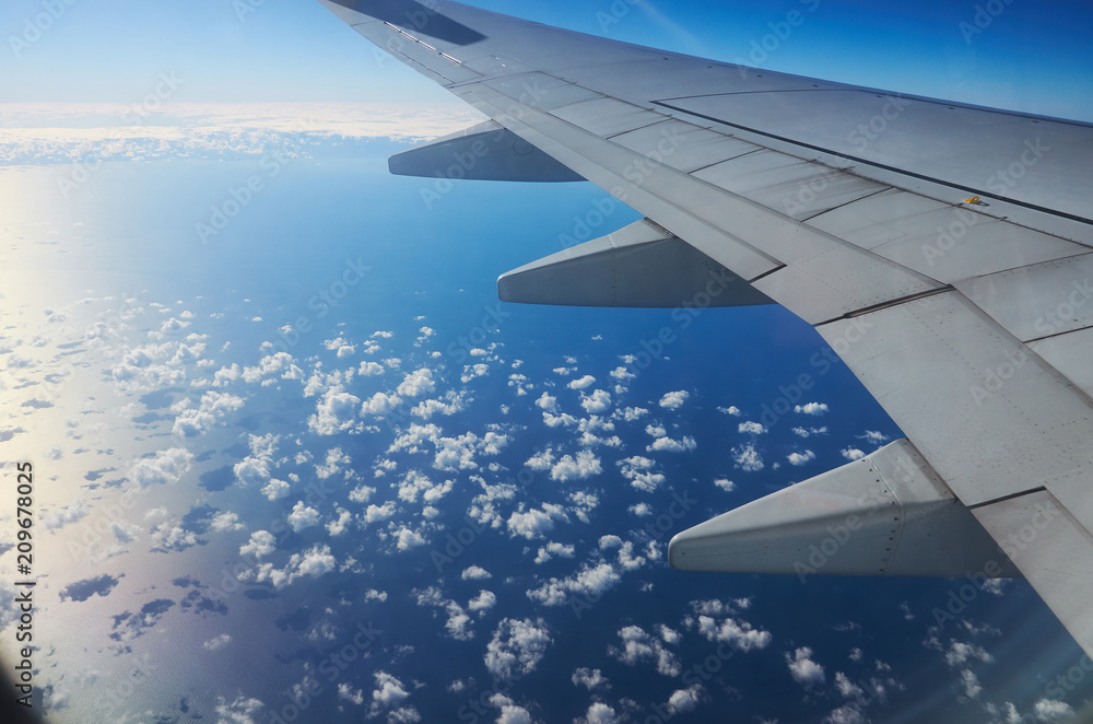 View from airplane window earth ground river and clouds travel tourism Istambul Turkey. Wing of an airplane flying above the clouds over ground cloudy stormy sky.