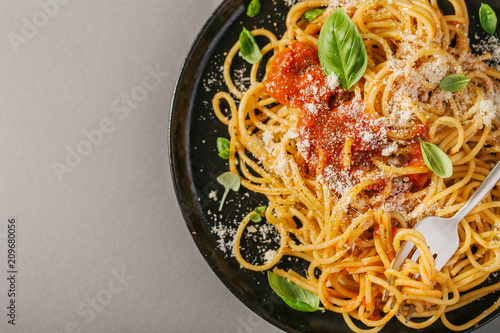 Dark plate with italian spaghetti on grey