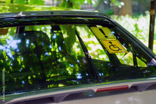 Obraz na płótnie Blue Badge Holder sign. White and blue sticker with a wheel chair symbol on stuck to the inside of a car window w salonie