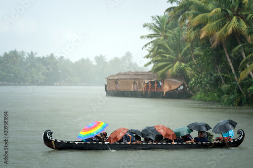 Monsoon time. People crossing a river by boat in rain photo