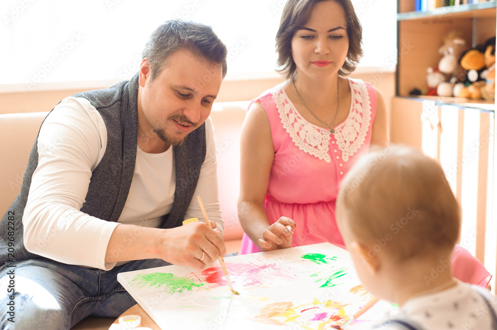 Mother and father drawing together with their child Mother and father drawing together with their child