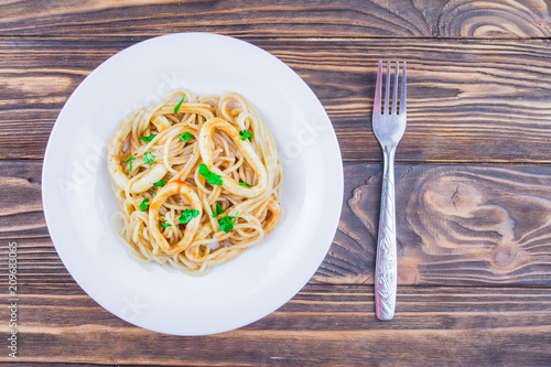 pasta with squid on a wooden background