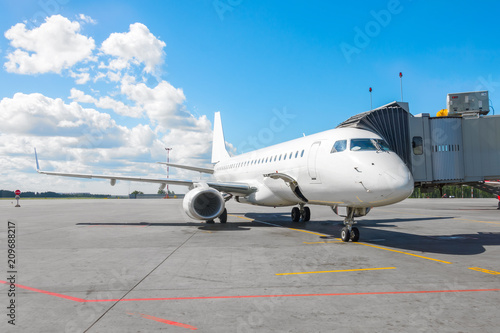 Commercial passenger airplane in the parking at the airport with a nose forward and a gangway. © aapsky