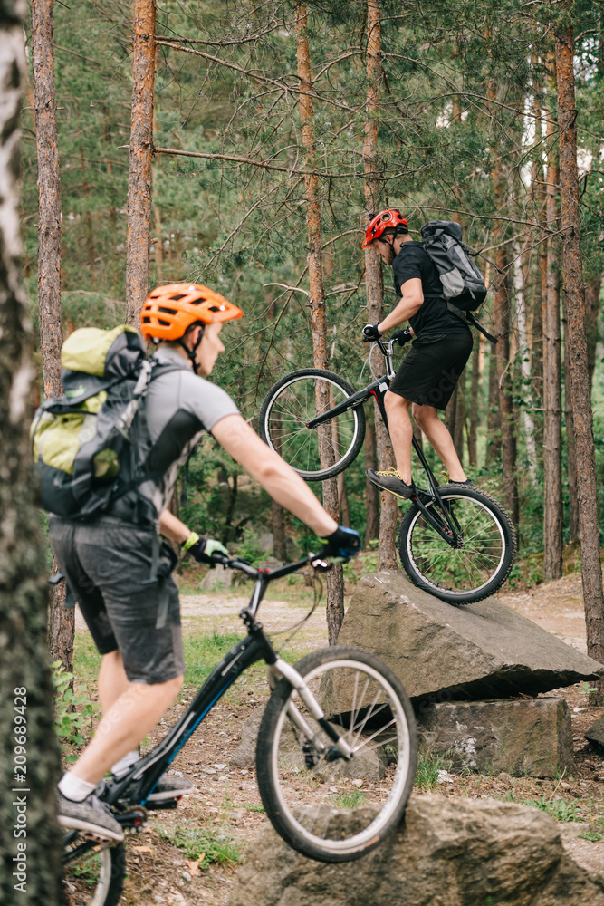Fototapeta premium young trial bikers having fun in pine forest