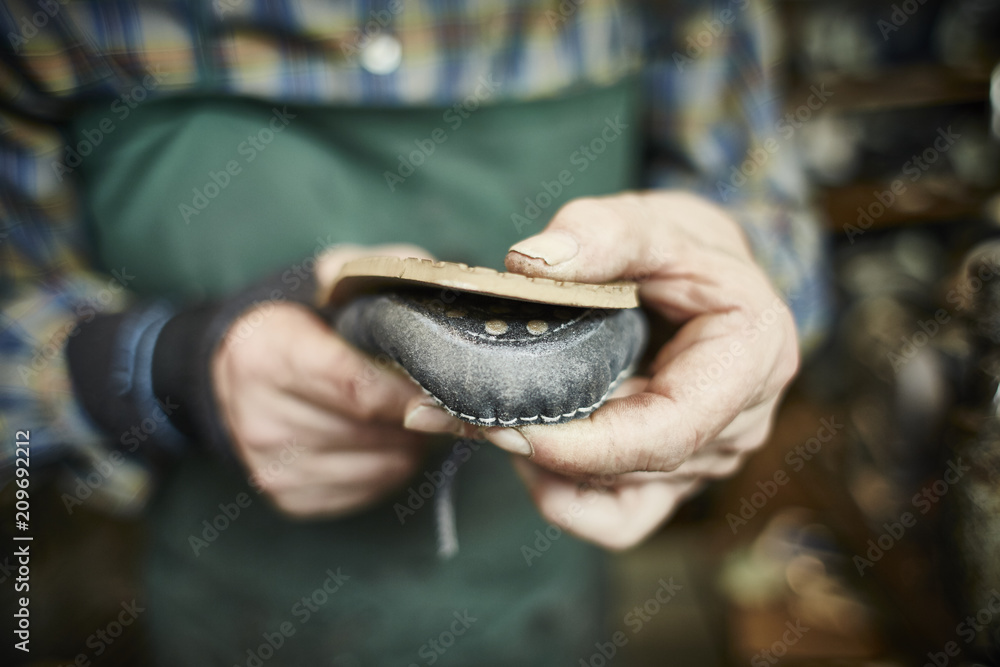 Fototapeta premium Schuster repariert der Sohle eines Schuhs