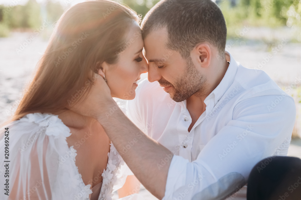 Fototapeta premium beautiful tender couple on beach with backlit