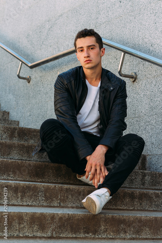 Photography Sexy man posing sits on the steps near railing