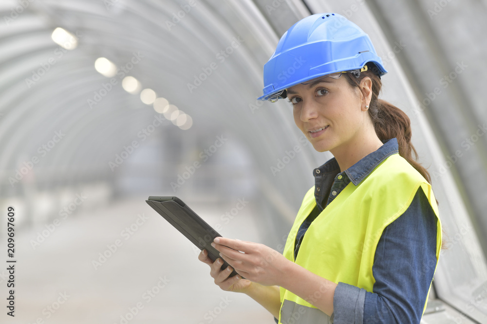 Industrial engineer connected with tablet in plant corridor Industrial engineer connected with tablet in plant corridor