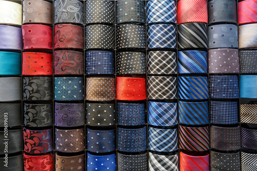 Big variety of different color neckties in a men clothing store