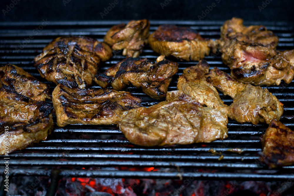 Pieces of fried meat on a grate, with smoke and fire. Fried meat on grate with smoke.