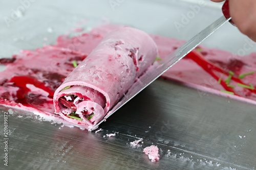 Thai roll ice cream is made by hand on the freezer. Sweet dessert made from natural berries and ingredients. The process of making food.