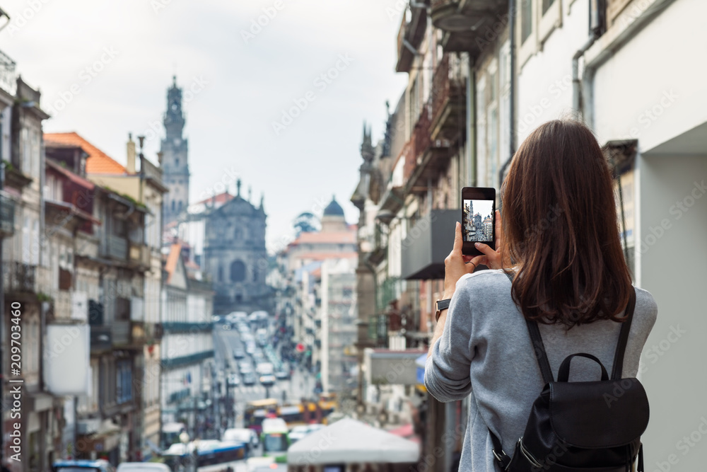 Young traveler woman taking a photo with her phone in Porto, Portugal Young traveler woman taking a photo with her phone in Porto, Portugal