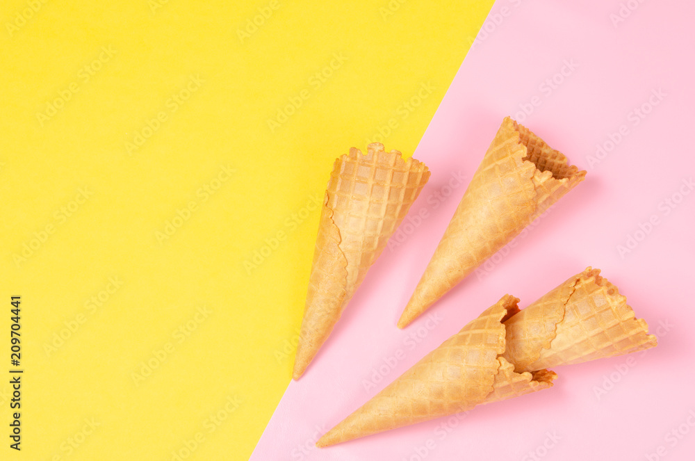 Ice cream waffle cones over bright yellow and sweet pink background with copy space for text, logo or wordings insertion or decoration, summer cold sweet snack Ice cream waffle cones over bright yellow and sweet pink background with copy space for text, logo or wordings insertion or decoration, summer cold sweet snack