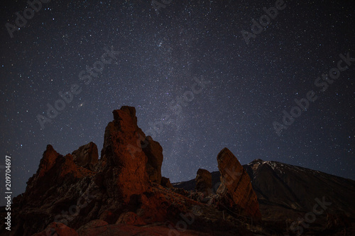 Night sky with lot of shiny stars above Roques de Garcia stone