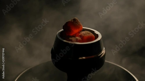 Hot coals in the hookah bowl in darkness closeup. black background