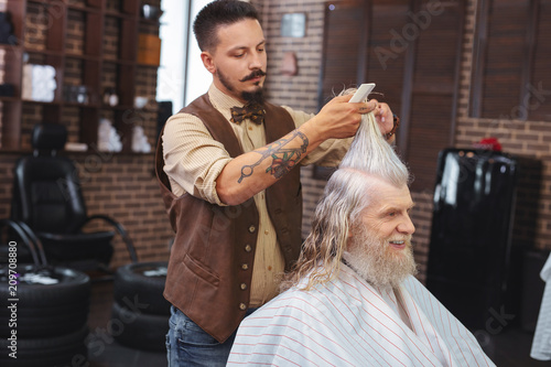 Do not move. Professional barber standing near customer while creating new style