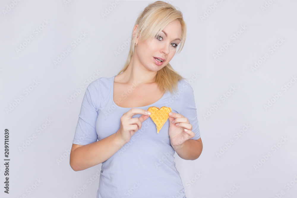 Happy blond woman holding in hands and showing belgian waffles Happy blond woman holding in hands and showing belgian waffles
