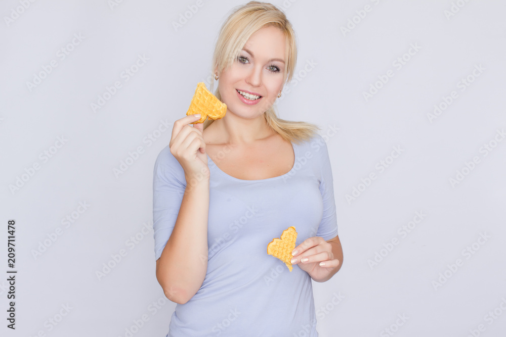 Happy blond woman holding in hands and showing belgian waffles Happy blond woman holding in hands and showing belgian waffles