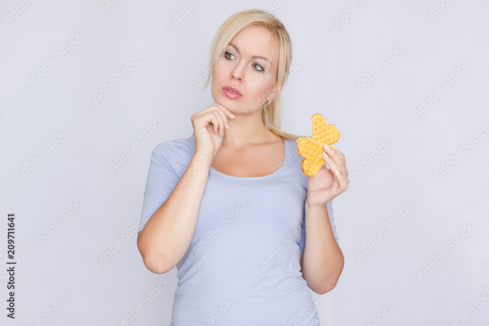Happy blond woman holding in hands and showing belgian waffles Happy blond woman holding in hands and showing belgian waffles
