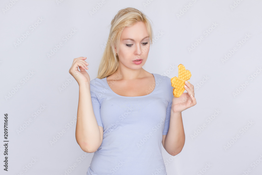 Happy blond woman holding in hands and showing belgian waffles Happy blond woman holding in hands and showing belgian waffles