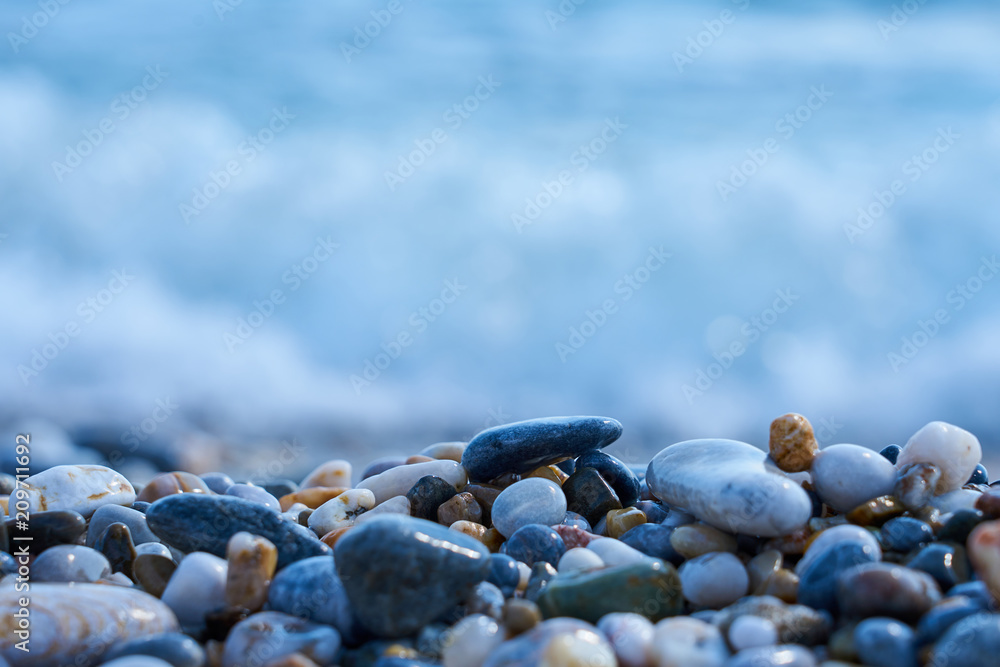 Stones on the beach with blured sea water on a background. Stones on the beach with blured sea water on a background.