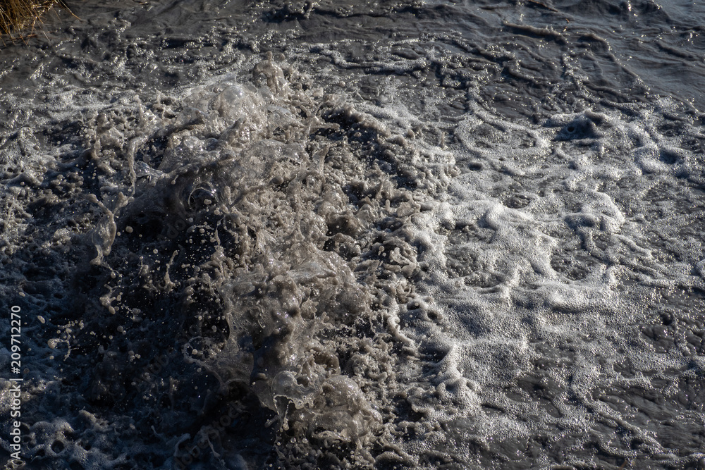 Water flows out of road sewage hatch. Drainage fountain of sewage. Water flows out of road sewage hatch. Drainage fountain of sewage.