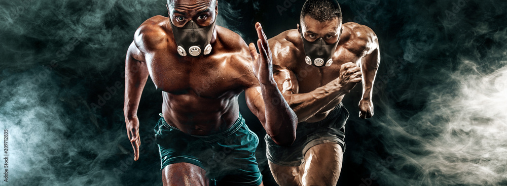 Competition of two strong athletic men sprinters in training mask, running, fitness and sport motivation. Runner concept with copy space. Dynamic movement.