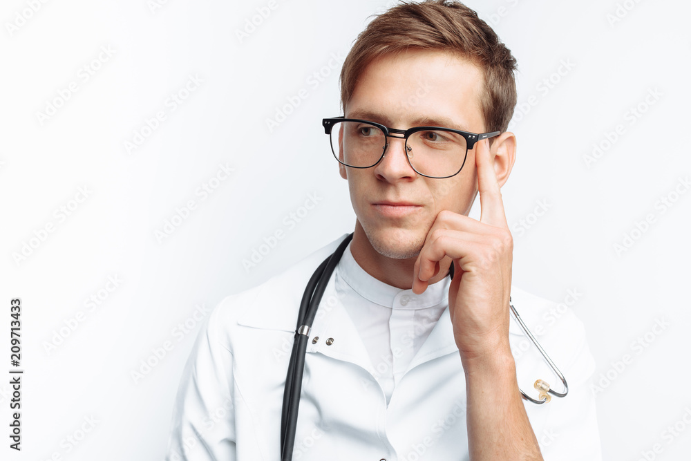 Portrait of a young doctor on a white background, Intern in the Studio, with a stethoscope on the neck Portrait of a young doctor on a white background, Intern in the Studio, with a stethoscope on the neck