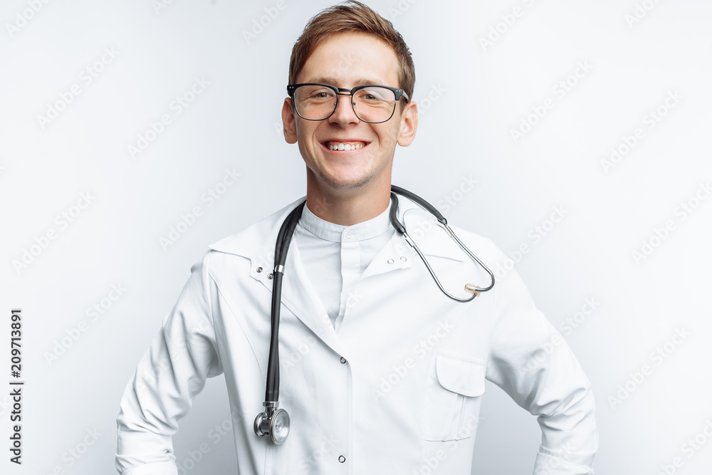 Portrait of a young doctor on a white background, Intern in the Studio, with a stethoscope on the neck Portrait of a young doctor on a white background, Intern in the Studio, with a stethoscope on the neck