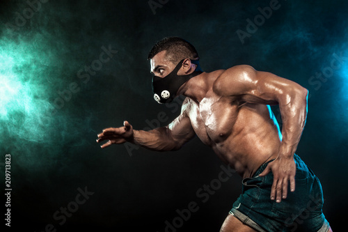 Strong athletic man sprinter in training mask, running, fitness and sport motivation. Runner concept with copy space. Dynamic movement. © Mike Orlov