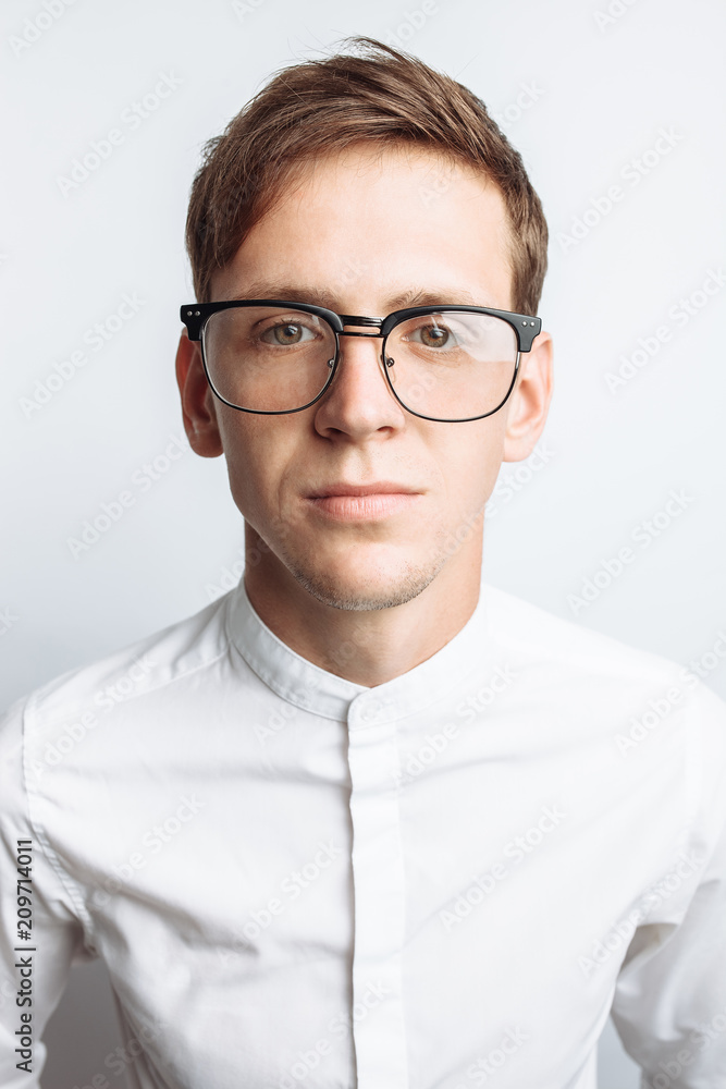 Portrait of young attractive guy in glasses, in white shirt, isolated on white background, for advertising, text insertion Portrait of young attractive guy in glasses, in white shirt, isolated on white background, for advertising, text insertion