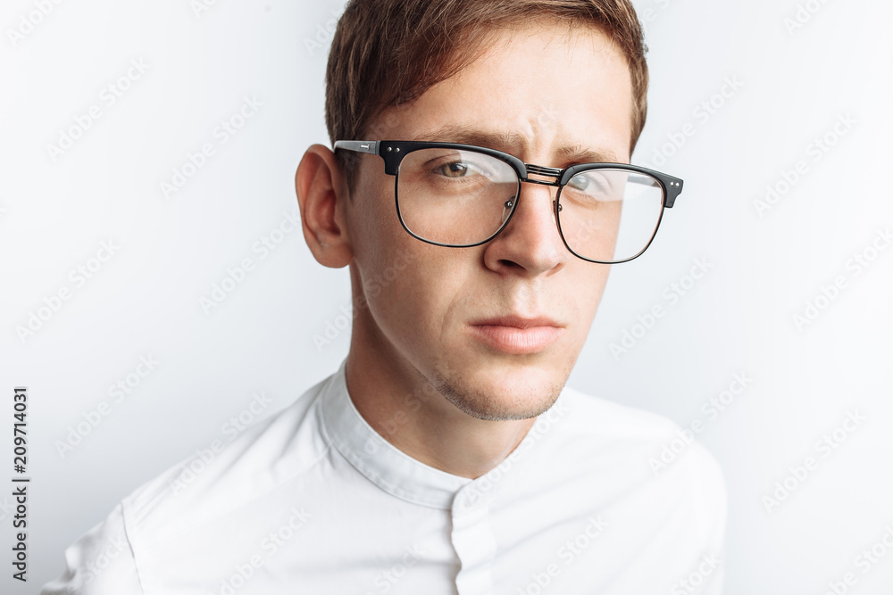 Portrait of young attractive guy in glasses, in white shirt, isolated on white background, for advertising, text insertion - obrazy, fototapety, plakaty 