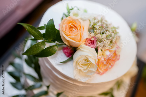 Wedding cake with natural roses and leaves.