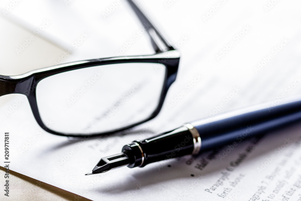 Signing the contract with pen and glasses in business work on of Signing the contract with pen and glasses in business work on of