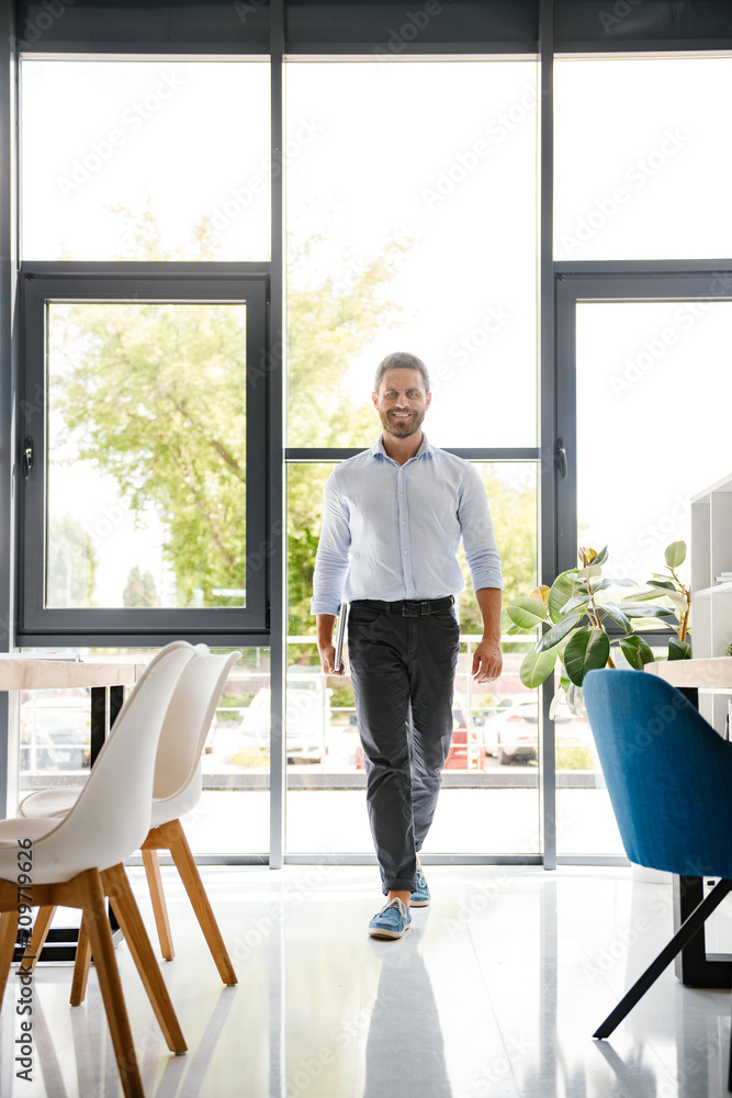 Smiling businessman walking at the office Smiling businessman walking at the office