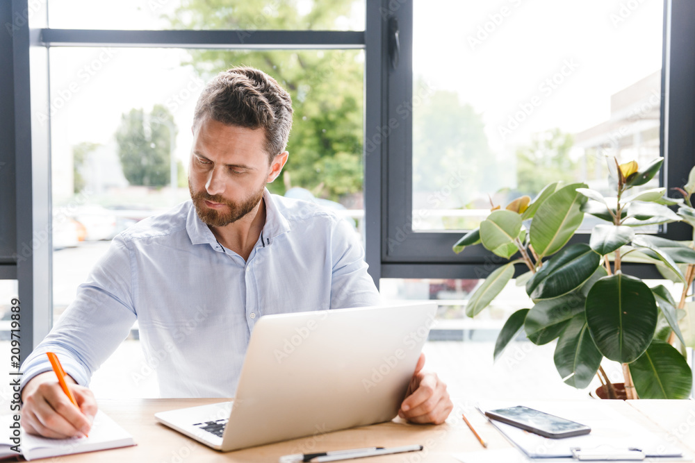 Concentrated businessman working on laptop computer Concentrated businessman working on laptop computer
