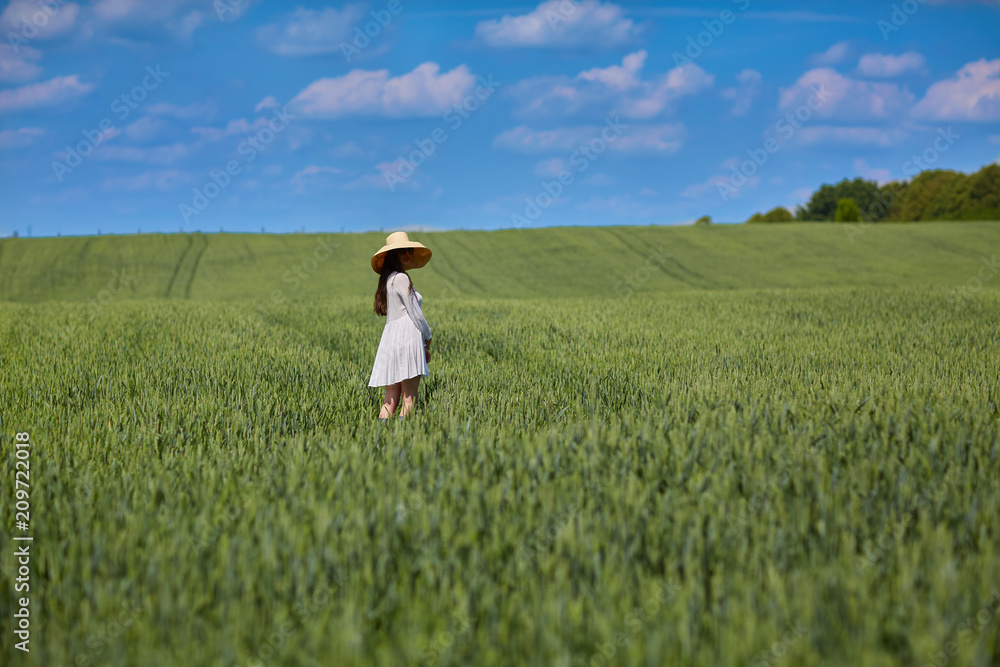 Beautiful girl dressed in white dress standing in the field Beautiful girl dressed in white dress standing in the field