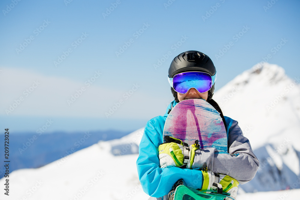 Photo of athlete in helmet with snowboard on snowy hill
