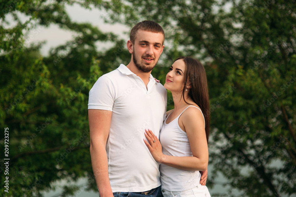 Dating in park. Love couple standing together on grass near the lake. Romance and love Dating in park. Love couple standing together on grass near the lake. Romance and love