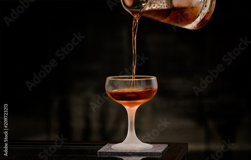 Pouring cocktail into coupe