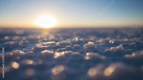 Salar de Uyuni at sunset. Timalapse of the salt flat of Salar de Uyuni during sunset, Bolivia. Focus on the foreground, on the salt crystals.