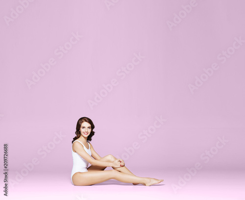 Young, fit and beautiful brunette woman in white swimsuit