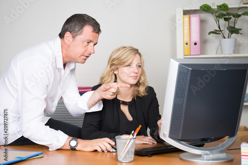 Businesswoman and businessman boss looking at computer together