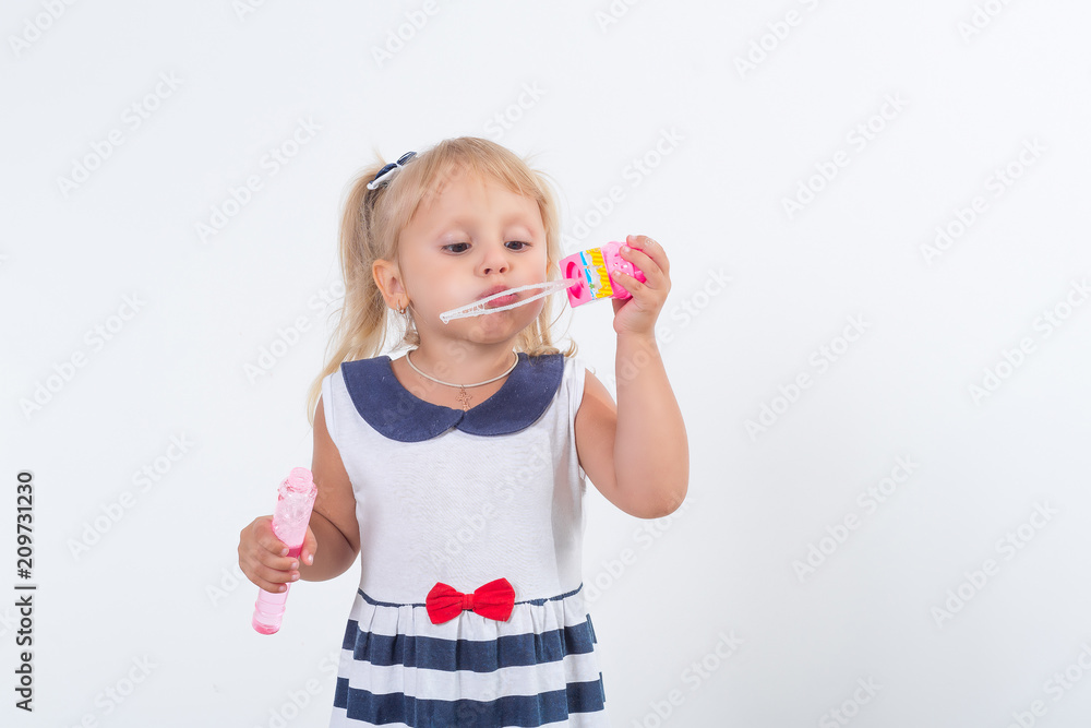 Little girl is playing with soap bubbles. Happy childhood. Joyful emotions. Little girl is playing with soap bubbles. Happy childhood. Joyful emotions.