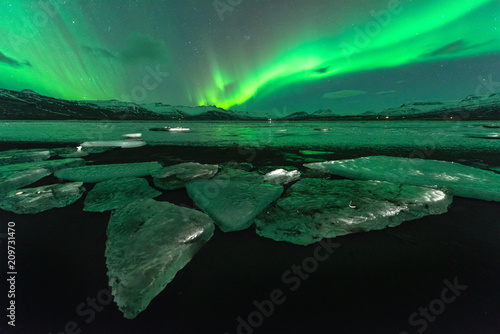 A beautiful green and red aurora dancing over the Jokulsarlon lagoon  Iceland