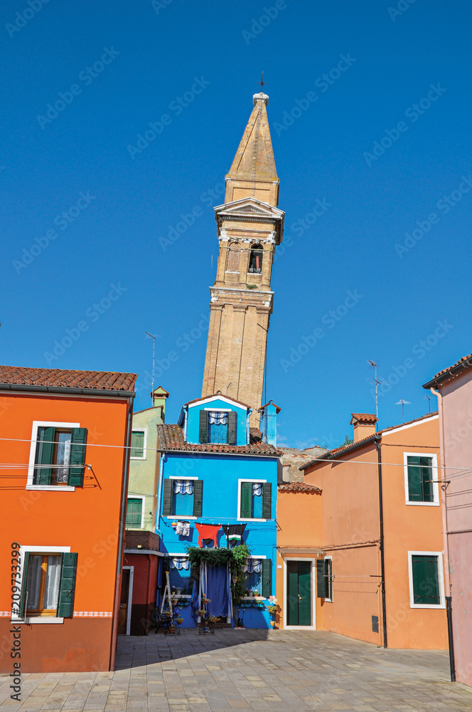 Obraz premium Overview of colorful buildings and leaning bell tower in a blue sunny day at Burano, a gracious little town full of canals, near Venice. Veneto region, northern Italy