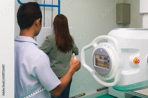 Asian male radiologist preparing and setting up X-rays.